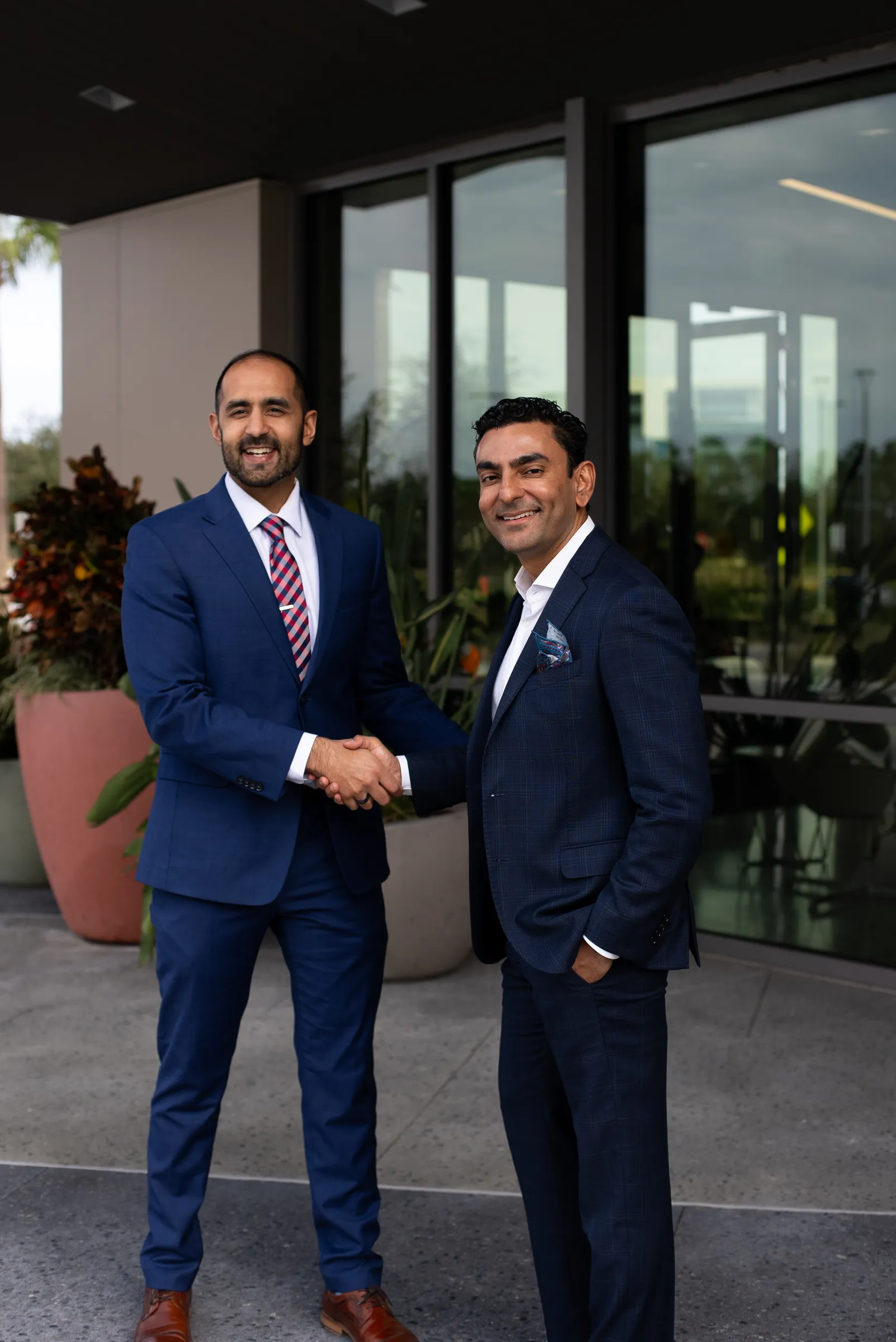 Two men in professional attire shaking hands